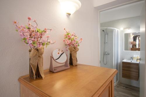 een badkamer met een kaptafel met bloemen en een spiegel bij Renovated Oasis 500m Beach AC Wi-Fi Pool Balcony in Albufeira