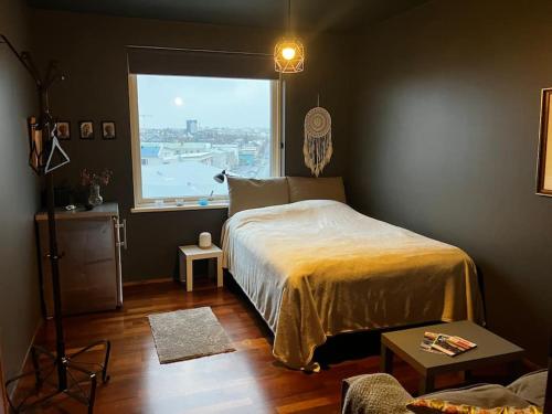 a bedroom with a bed and a large window at Private room in a shared apartment with amazing view in Reykjavík
