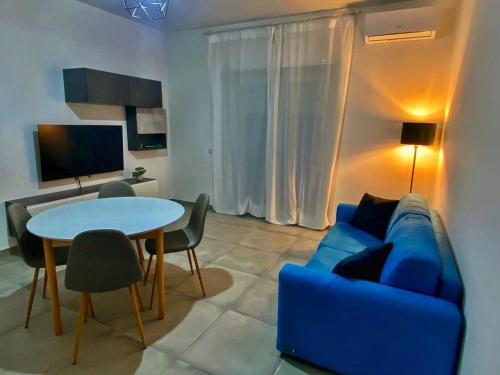 uma sala de estar com um sofá azul e uma mesa em Moderno Appartamento - Anzio em Anzio