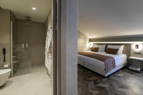 a bedroom with a bed and a bathroom with a shower at Mustafa Cappadocia Resort in Urgup