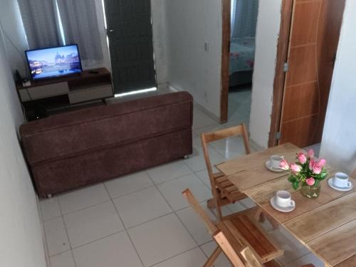 uma sala de estar com uma mesa de jantar e uma televisão em CASA DE PRAIA DO MINEIRO - A 300 metros do MAR em Nova Viçosa