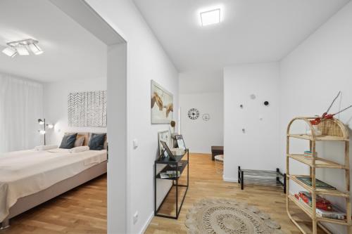 a white bedroom with a bed and a book shelf at Sali Homes/ R1 Gemütliches Apartment am Fluss in Bayreuth