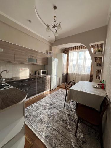 a kitchen with a table and a dining room at PROMENADE BISHKEK in Bishkek