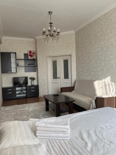 um quarto com uma cama e uma sala de estar com um sofá em PROMENADE BISHKEK em Bishkek