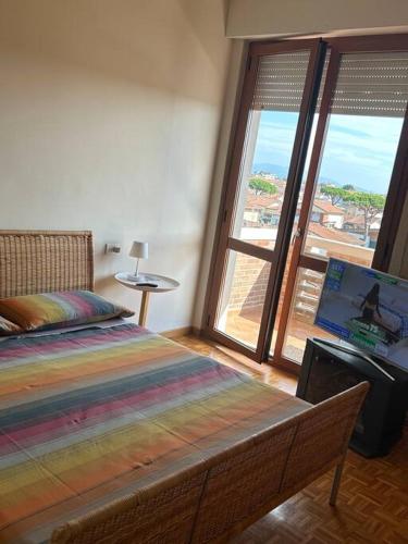 Schlafzimmer mit einem Bett und einem Fenster mit Aussicht in der Unterkunft Residenza Versilia in Viareggio