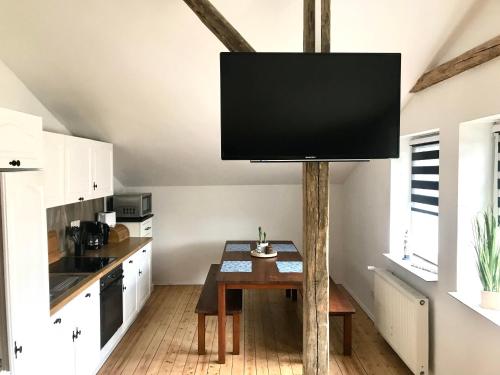 a tv on a pole in a kitchen with a table at Ferienwohnung Ostseeglück in Neu Jörnstorf