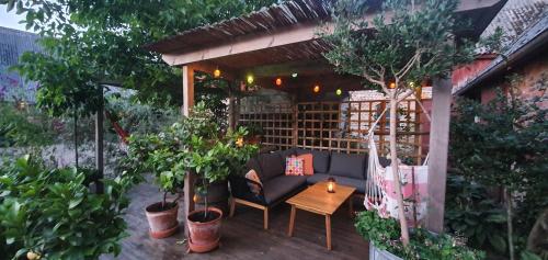 a patio with a couch and a table and trees at Aplagårdens vingård in Helsingborg