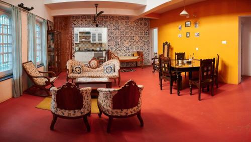 ein Wohnzimmer mit Stühlen und ein Esszimmer in der Unterkunft Zorba the Buddha in Begusarai