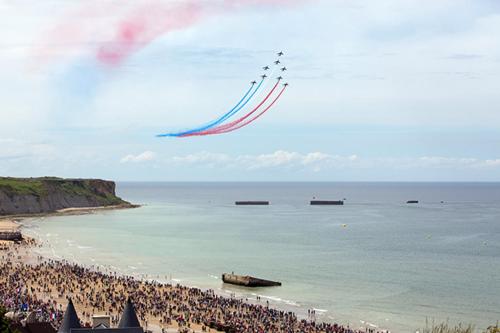 a group of people on a beach flying a kite at gite de la laiserie in Mesnil-Clinchamps