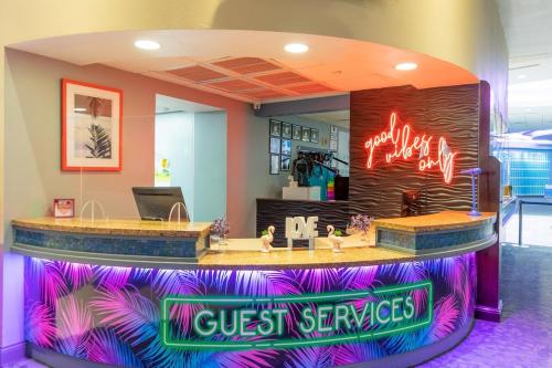 a lobby with a guest services counter with neon signs at Wyndham Ocean Walk Resort - 2 Bedroom Oceanview #1 in Daytona Beach