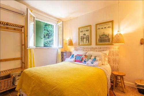 une chambre avec un lit jaune avec une fenêtre dans l'établissement Villa Jean-Pierre. Infinity pool and view in Tourrettes-sur-Loup, à Tourrettes-sur-Loup