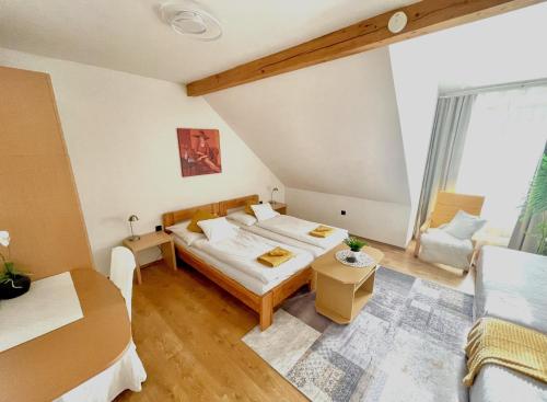 ein kleines Zimmer mit einem Bett und einem Sofa in der Unterkunft Alpesi Apartman in Sopron