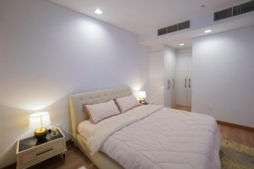 a bedroom with a large bed and two lamps at Luxury Apartment by the Sea with Amazing Amenities at Pearl Qatar in Doha