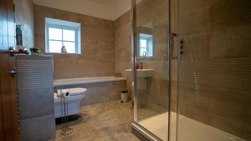 a bathroom with a shower and a toilet and a sink at Northumberland Luxury Stays - The Shearling in West Chevington