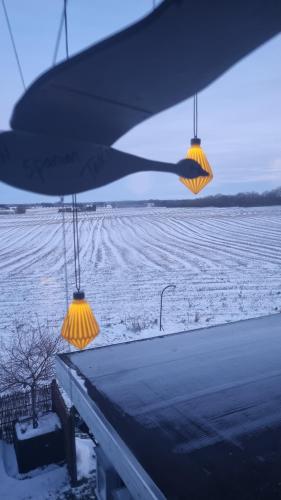 two lights on top of a porch with a snow covered field at Marsvinslund bed and breakfast in Viborg