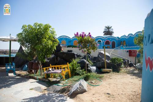 a garden with a bench and trees in front of a building at Kato Waidi Nubian Resort in Aswan