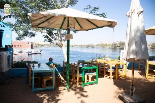 a table with an umbrella next to a river at Kato Waidi Nubian Resort in Aswan