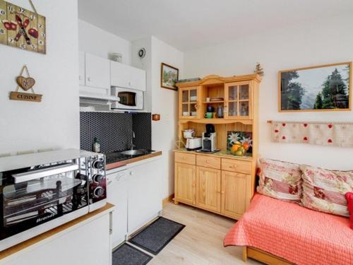 Cette chambre comprend une petite cuisine avec un lit rouge. dans l'établissement Appartement T2 lumineux, 6 pers., parking, proche commerces et ski - FR-1-403-39, à Barèges