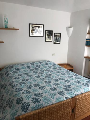 um quarto com uma cama com um cobertor azul em Villa Molara em Baja Sardinia