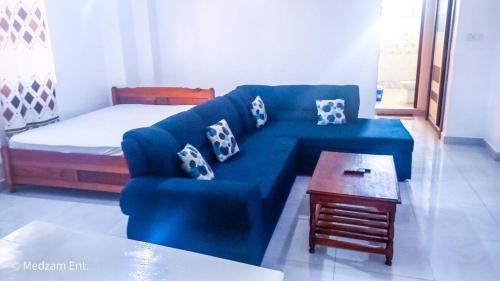 sala de estar con sofá azul y cama en One Bedrooms with 2 Bed Kisimani Heights Apt, en Mombasa