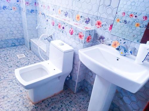 y baño con aseo blanco y lavamanos. en One Bedrooms with 2 Bed Kisimani Heights Apt, en Mombasa