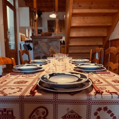 une table avec des assiettes et des verres au-dessus dans l'établissement LE NID ROUDELA, à Garin