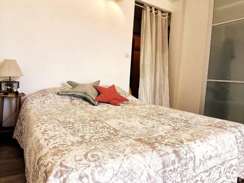 une chambre avec un lit avec deux oreillers dessus dans l'établissement Studio Rénové avec Grande Terrasse et Wifi à Balaruc-les-Bains - FR-1-553-230, à Balaruc-les-Bains