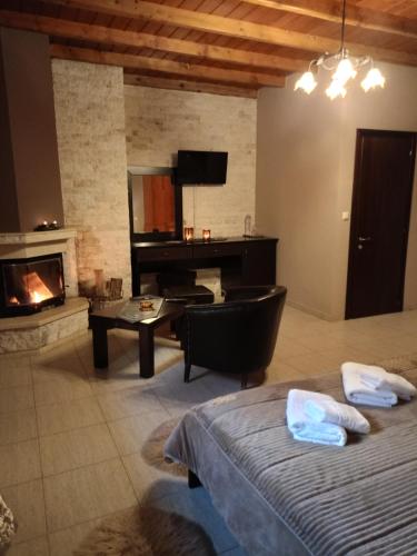 a living room with a bed and a fireplace at Hotel Edem in Kato Loutraki