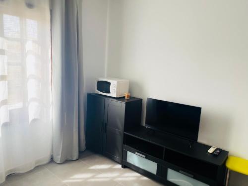 a tv sitting on top of a black dresser with a microwave at Sweet Home San Blas in San Miguel de Abona