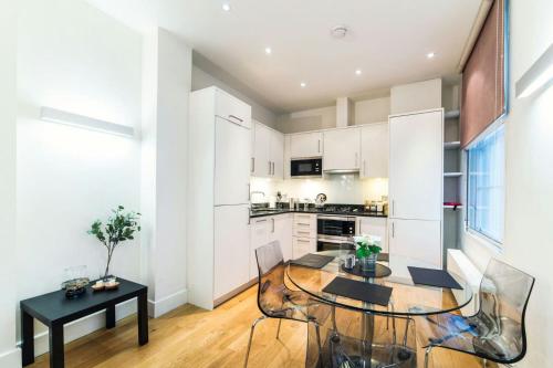 a kitchen with a table and chairs in a room at StayInn Aldgate East in London