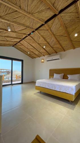 a large bedroom with a bed and a large window at Ananda Beach Camp in Nuweiba