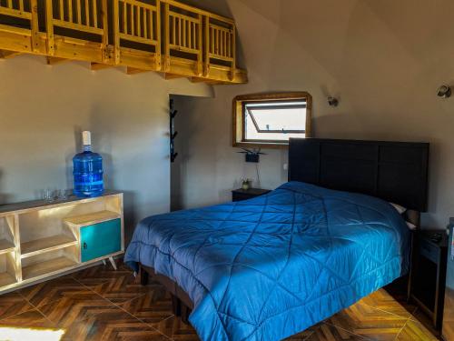 Un dormitorio con una cama azul y una ventana en Domo ruta del vino Colchagua, en Peralillo