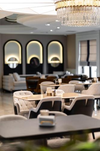 a restaurant with tables and chairs and a chandelier at ALİBA HOTEL in Edirne