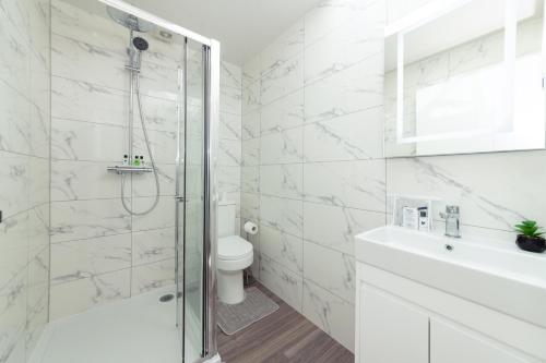 a bathroom with a shower and a toilet and a sink at Well Equipped Apartment Guaranteed Weekly & Monthly Savings in Reading