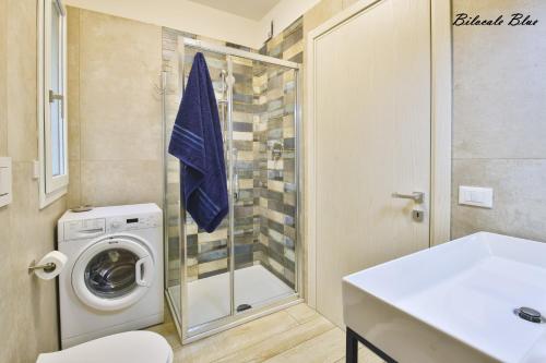 a bathroom with a washing machine and a glass shower at Casa Stefania Rimini in Rimini