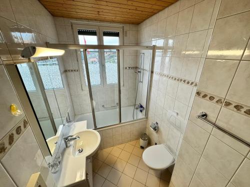 a bathroom with a sink and a toilet and a shower at Burgheim Siesta in Oberhofen am Thunersee