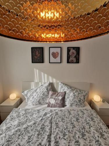 a bedroom with a bed and a chandelier at Wörthersee: Gemütliche Wohnung in Klagenfurt