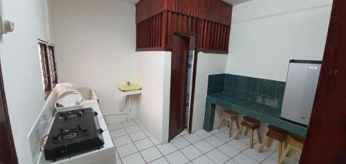 a kitchen with a washing machine and chairs in it at Hotel Allan Veintiocho Puntarenas in Puntarenas