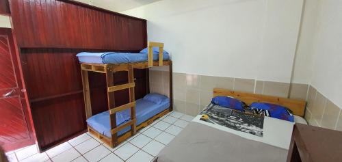 a room with two bunk beds and a table at Hotel Allan Veintiocho Puntarenas in Puntarenas