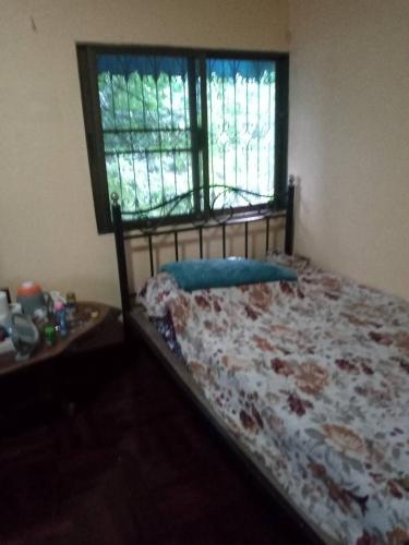 a bedroom with a bed and a window and a table at NP Prime FREE WiFi in Bangkok