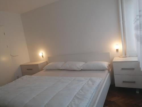 een slaapkamer met een wit bed en 2 nachtkastjes bij TINA in Karlovac