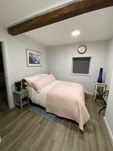 a bedroom with a bed and a clock on the wall at The Old Barn one bedroom apartment in Overton in Overton