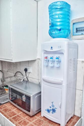 a refrigerator with a blue bowl on top of it at Magnolia Apartments in Kisumu