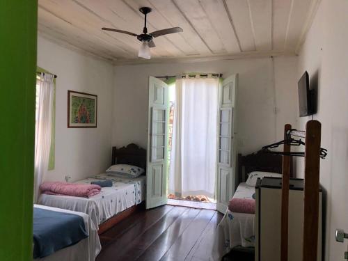 1 dormitorio con 2 camas y ventilador de techo en Pousada Coco Verde en Parati