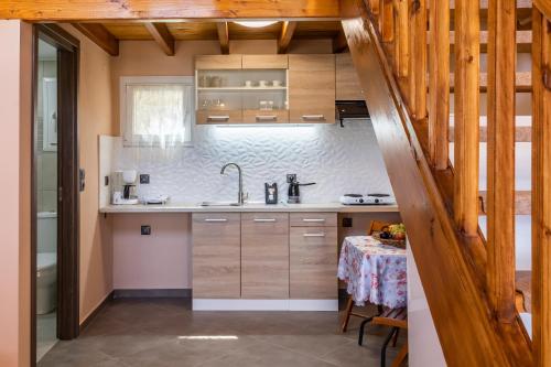 een keuken met houten kasten en een tafel bij Irene's Paradise apartments in Skopelos Town
