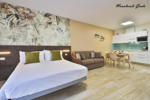 a bedroom with a bed and a couch and a kitchen at Casa Stefania Rimini in Rimini