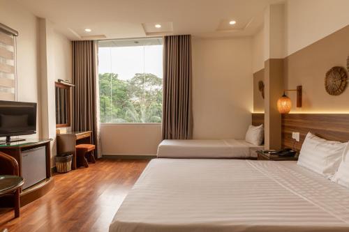 a hotel room with two beds and a television at Lantern Hotel in Ho Chi Minh City