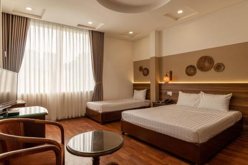Habitación de hotel con cama y mesa en Lantern Hotel en Ho Chi Minh