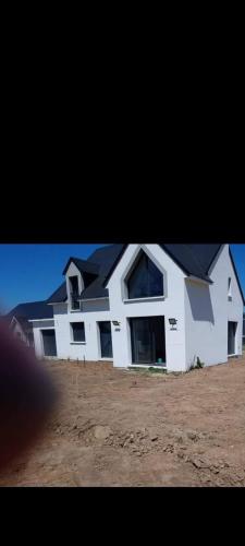 une grande maison blanche avec un toit noir dans l'établissement chambre à louer, à Magny-en-Bessin