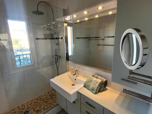 a white bathroom with a sink and a mirror at Le Masters in Mandelieu-la-Napoule